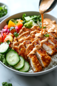 This image shows a generous drizzle of spicy mayo and savory sauce over the chicken katsu rice bowl, bringing all the flavors together beautifully.