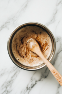 This image shows butter melting into warm milk, ensuring a smooth and well-incorporated mixture for the cinnamon roll dough.