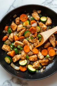 This image shows peas, cherry tomatoes, and zucchini being added to the sautéed ingredients, bringing freshness and color to the dish.