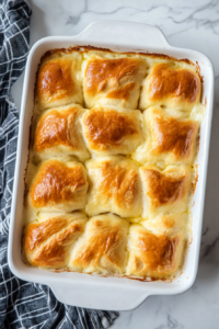 This image shows the crescent rolls in the oven, baking until golden brown on top, with the creamy sauce bubbling around the edges.