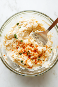 This image shows shrimp and minced garlic sizzling in a pan, enhancing the seafood flavors of the dip.