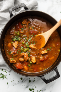 This image shows the gumbo mixture coming to a rolling boil before being reduced to a simmer, allowing the flavors to meld together slowly over time.