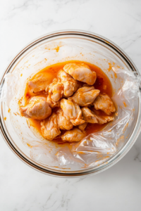 This image shows the chicken covered and marinating in a bowl, allowing the flavors to soak in for tender, juicy meat.