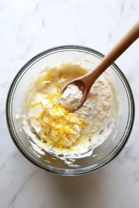 This image shows a mixing bowl filled with dry ingredients—flour, sugar, salt, and yeast—being whisked together for an even dough consistency.