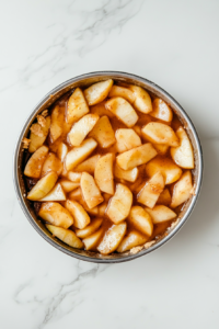 A warm bowl of freshly made apple pie filling resting, allowing the flavors to meld and the mixture to thicken for a perfectly textured pie filling.