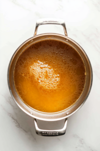 This image shows homemade dumpling strips being carefully added to the simmering broth, ready to cook until tender.