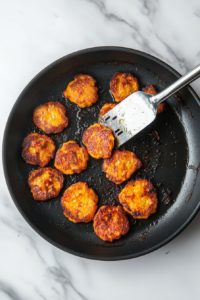 flipping the fritters for an even finish all around on all the sides to make properly crispy