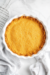 This image shows a golden-brown baked pie crust resting on a wire rack, cooling to achieve a crisp texture.