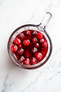 This image shows a saucepan on a stove with a gelatin mixture being prepared.