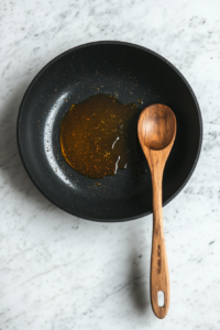 This image shows a pan with olive oil being heated on the stovetop, getting ready for sautéing the onions and spices for the slow cooker chicken and rice recipe.