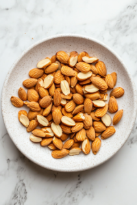 This image shows freshly toasted almonds spread out on a plate, cooling down to maintain their crunch before being mixed into the salad.