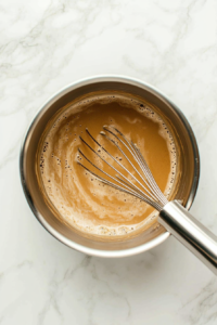 mixing-cream-and-soy-sauce-into-the-tequila-infused-sauce-for-the-pasta