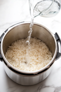 This image shows water being poured into an Instant Pot, preparing it to cook perfectly tender rice.