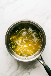 pouring-chicken-stock-tequila-and-lime-juice-into-the-pan-for-the-sauce
