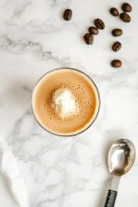 This image shows fresh cold milk being poured into a glass, creating a smooth base for the creamy whipped coffee topping.