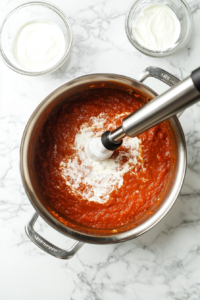 pouring-heavy-cream-into-the-sauce-and-blending-for-a-silky-finish
