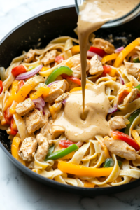 pouring-the-creamy-tequila-infused-sauce-over-the-fettuccine