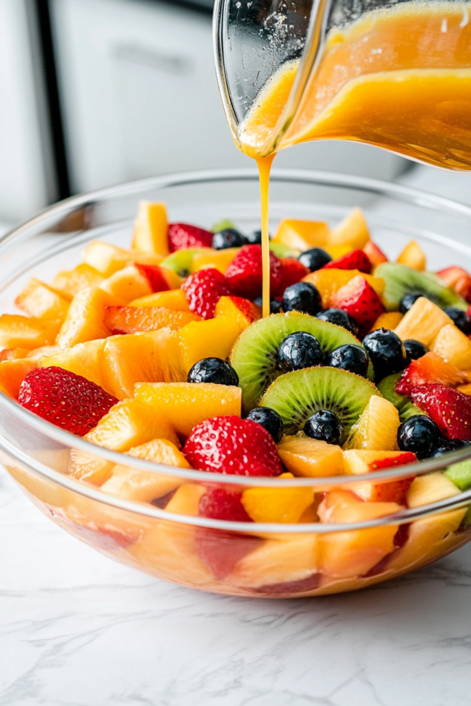 pouring-the-flavorful-sauce-over-the-layered-fruits-in-a-glass-bowl-for-german-fruit-salad-6097099-683x1024