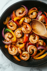 This image shows vibrant bell peppers and onions being sliced on a wooden cutting board, adding fresh flavors and color to the dish.