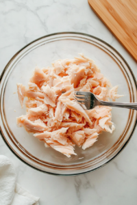 This image shows whitefish being carefully flaked after the skin has been removed, preparing it for the salad mixture.
