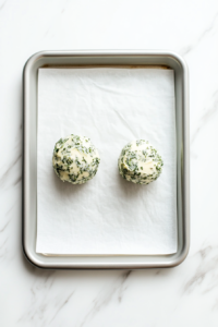 This image shows the herb-infused butter being shaped into a log and wrapped in parchment paper before being placed in the freezer to firm up for easy stuffing.