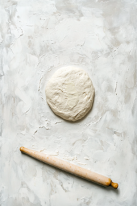 This image shows the babka dough being rolled out into a thin rectangle, preparing it for the sweet cheese filling.