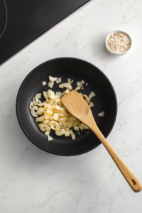 This image shows finely chopped onions being sautéed in a pan until soft and translucent, creating a flavorful base for the slow cooker chicken and rice.