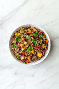 This image shows the final presentation of wild rice pilaf, beautifully arranged in a bowl with garnishes, ready to be enjoyed.