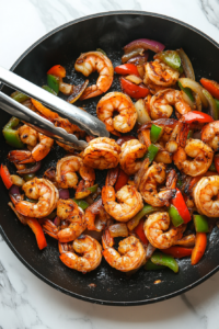 This image shows shrimp being flipped in a skillet, ensuring both sides are evenly cooked to a juicy, flavorful finish.