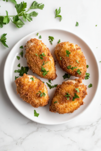 This image shows a freshly cooked Chicken Kiev being sliced open, revealing a molten, buttery herb filling inside a perfectly golden, crispy crust, ready to be served.