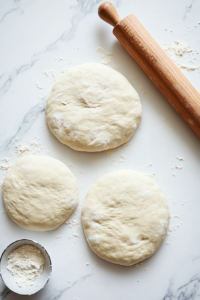 spreading-creamy-alfredo-sauce-on-rolled-out-dough