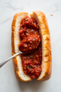 spreading-marinara-sauce-on-toasted-garlic-bread