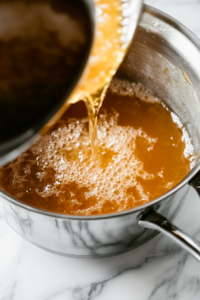 This image shows thick, creamy chicken soup being added to the broth, creating a rich and velvety base for the dish.