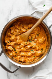 tossing-broiled-chicken-into-the-creamy-tikka-masala-sauce