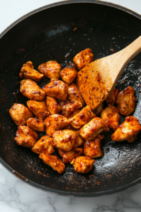 This image shows cooked chicken being carefully removed from the wok, ensuring it stays tender while preparing the next step.