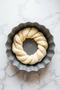 This image shows the filled babka dough being rolled, twisted, and shaped into a beautiful spiral pattern for a visually stunning final result.