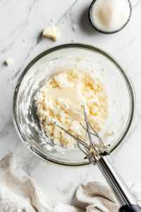 This image shows butter and sugar being creamed together until light and fluffy, creating the perfect base for the cake batter.