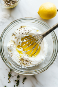 This image shows a creamy coleslaw dressing being mixed in a bowl, blending mayonnaise, vinegar, and seasonings for a tangy, flavorful topping.