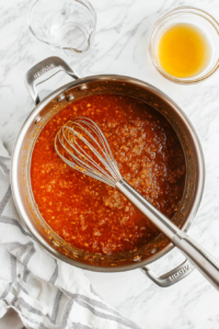 whisking-water-and-honey-into-the-sauce-for-balance-and-smooth-consistency