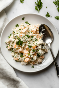 This image shows the finished whitefish salad served alongside bagels and bread, ready to enjoy.
