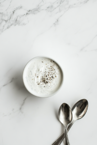 This image shows a finished bowl of Wingstop-style ranch dressing, garnished lightly with herbs and ready to be served alongside a variety of dishes.