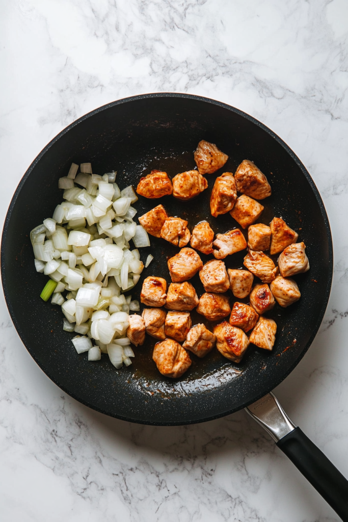 onions-and-garlic-added-to-skillet-with-seared-chicken