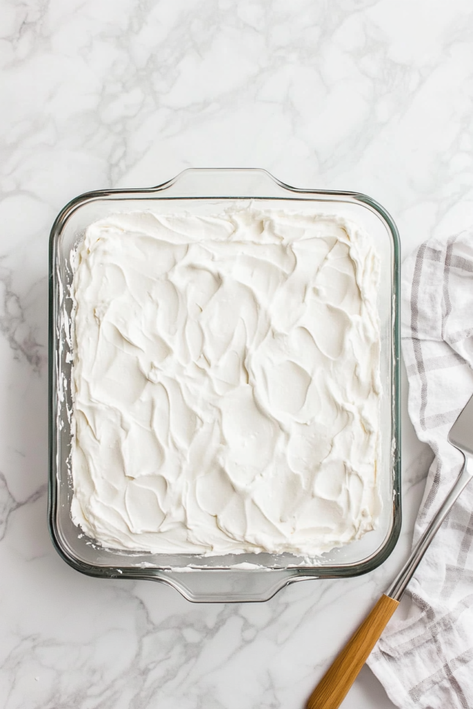 adding-final-whipped-topping-layer-and-refrigerating-the-dessert-for-serving