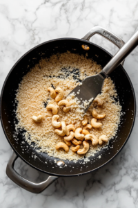 adding-semolina-and-cashews-to-hot-ghee-for-roasting-in-sooji-halwa