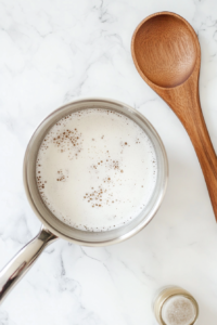This image shows yeast being added to the sugar-water mixture and left to activate, creating a bubbly foam that signals it's ready for mixing into the dough.