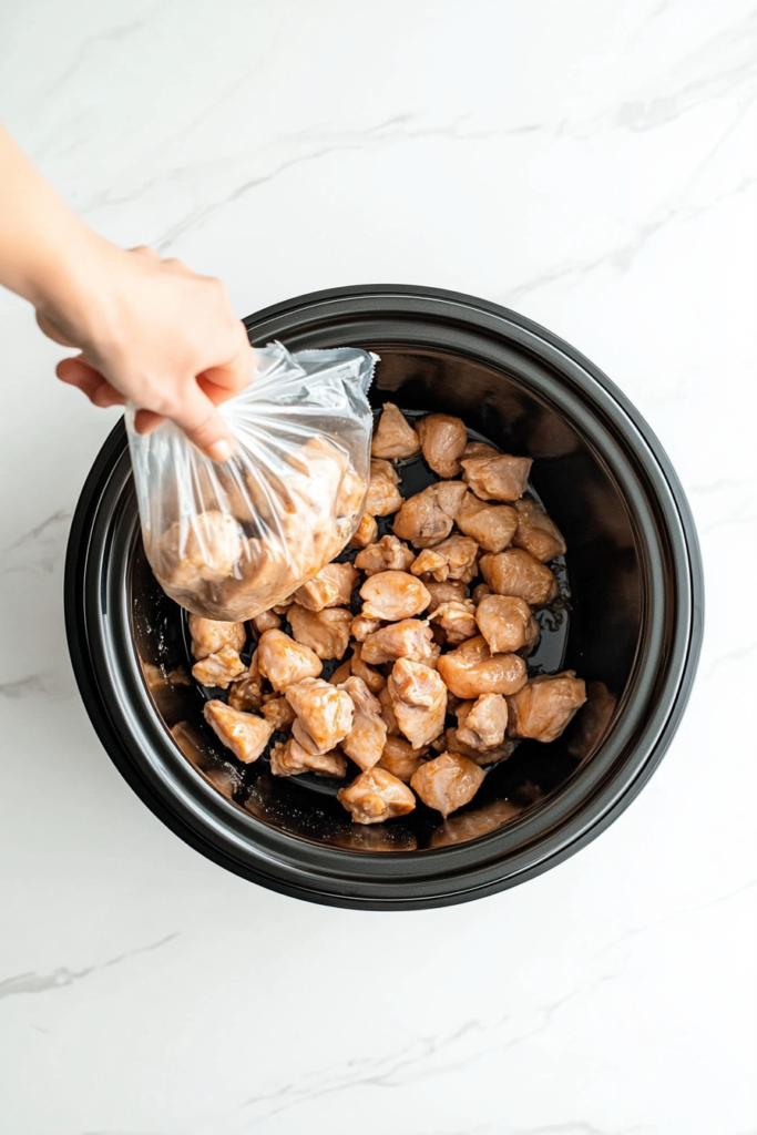adding-chicken-pieces-to-the-slow-cooker-5976304-683x1024