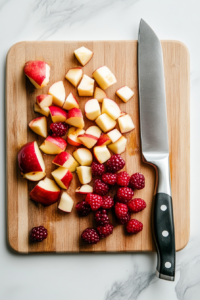 This image shows various fruits being chopped into smaller pieces, preparing them for the simmering process in the Kompot recipe.