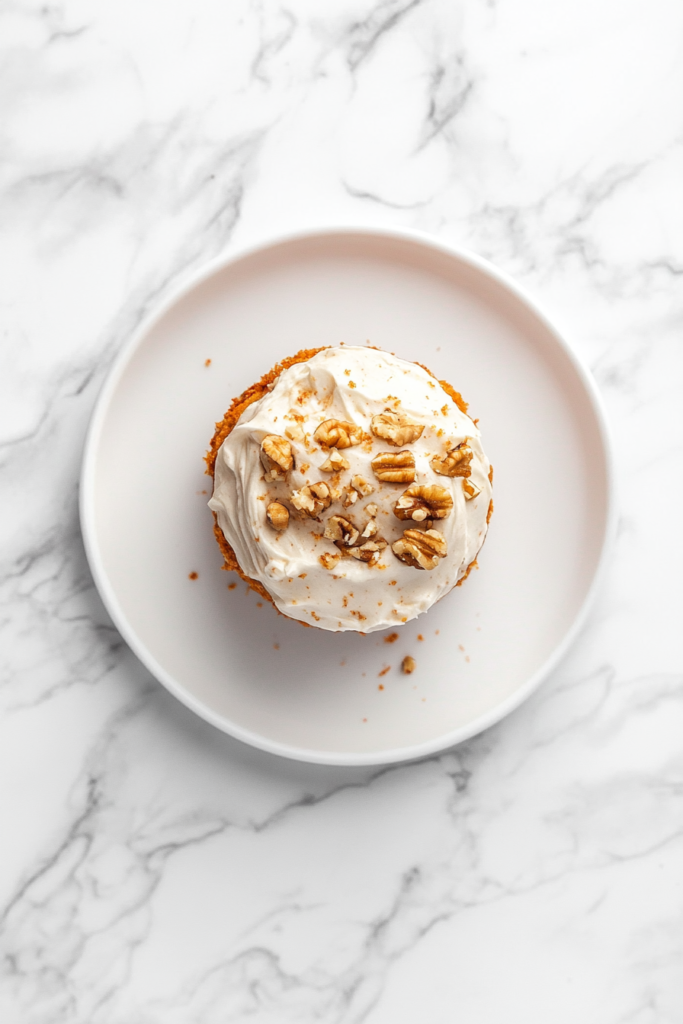 This image features a moist and flavorful classic carrot cake, topped with a creamy layer of frosting and sprinkled with chopped pecans, making it a delightful treat for any celebration.