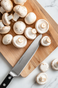 This image shows fresh mushrooms being cleaned and sliced, ensuring they are ready for cooking in the flavorful Mushroom Masala.