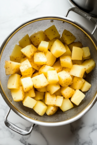draining-the-cooked-potatoes-in-a-colander-for-colcannon